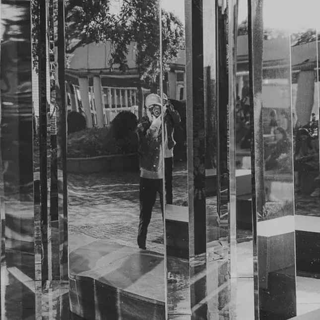 Self portrait in front of a mirror wall fountain installation.